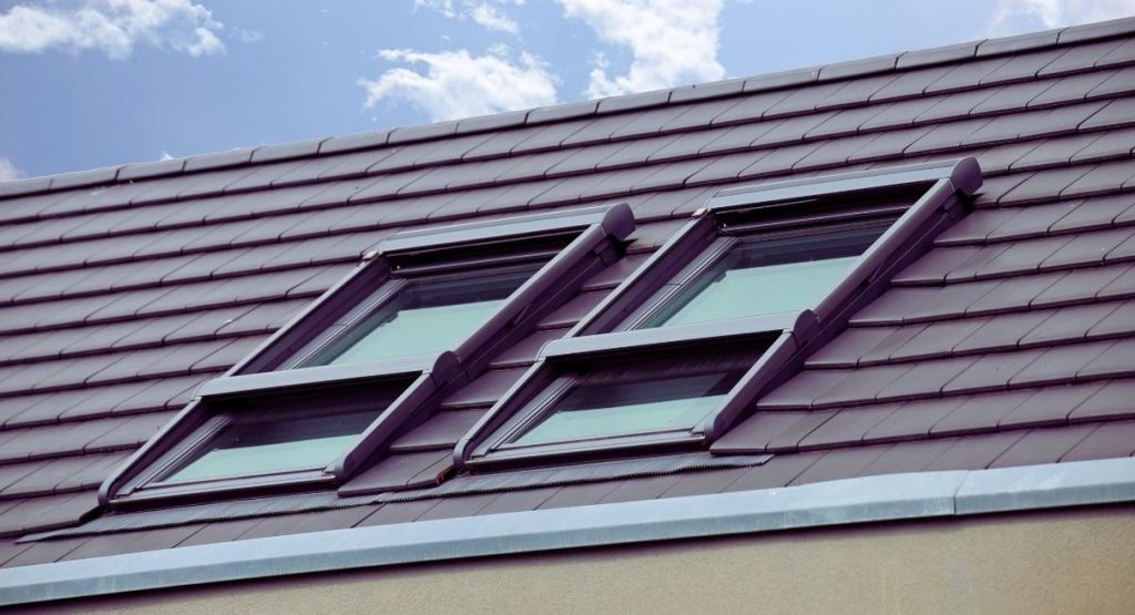 Verrière avec fenêtre de toit sur toiture en tuiles de maison ancienne