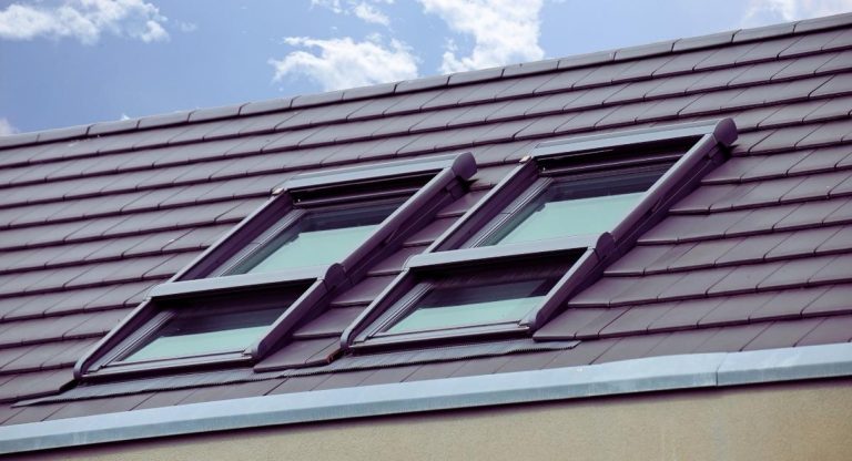 Verrière avec fenêtre de toit sur toiture en tuiles de maison ancienne