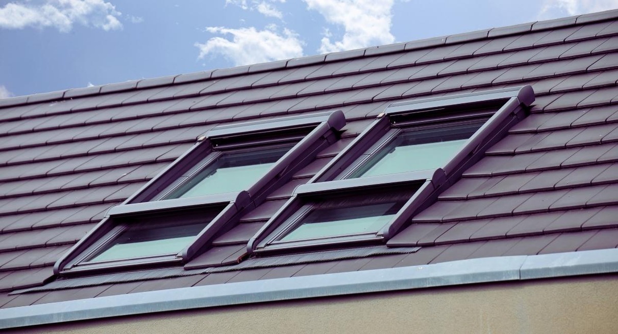 Verrière avec fenêtre de toit sur toiture en tuiles de maison ancienne